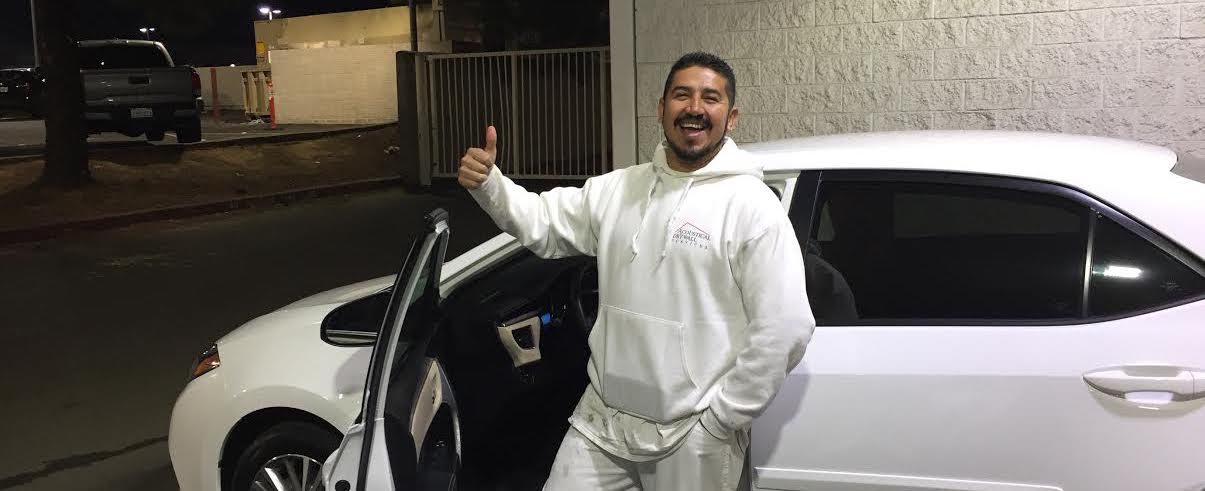 acoustical drywall services employee standing in front of car